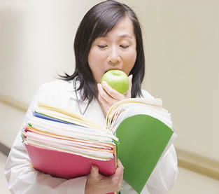 asian-medical-worker-with-patient-files-eating-apple