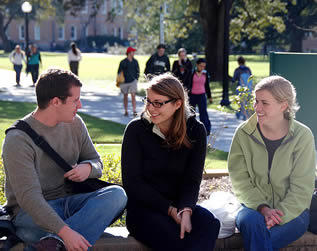 three-college-students-sitting-at-school