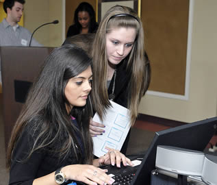 two-female-college-students-working-on-laptop