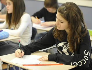 girl-student-writing-at-classroom-desk