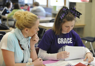 two-young-college-girls-sitting-at-desk