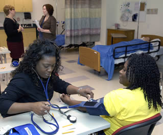 Nusing assistant on the job taking blood pressure