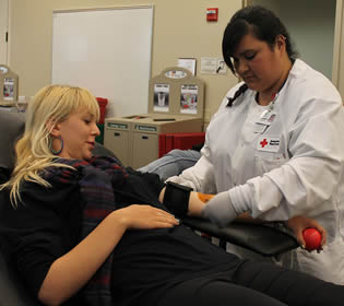 Nursing assistant worker taking blood pressure of patient