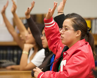 college-students-raising-hands-in-class