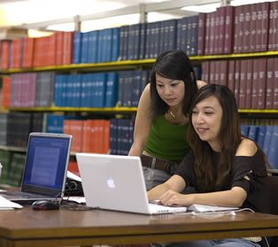 two-asian-students-using-laptop-at-school