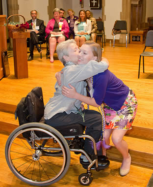 nursing-grad-hugging-elderly-woman-in-wheelchair