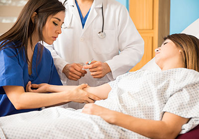 Nursing assistant helping patient in bed