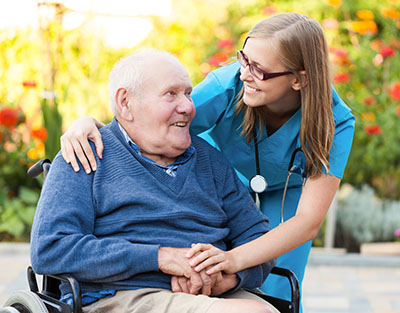 Nursing assistant working with senior citizen in wheelchair