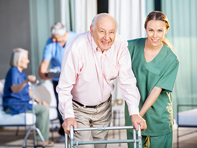 CNA helping elderly patient at nursing home